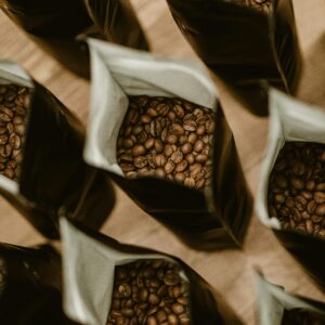 Several bags filled with fresh coffee beans from a high angle view, showing abundance.